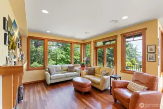 Living room with deck off to the right.  Double doors open to the balcony and protect view.