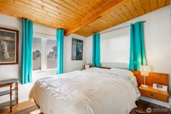 Extra room addition that is being utilized as a bedroom. Knotty pine ceiling and engineered flooring.