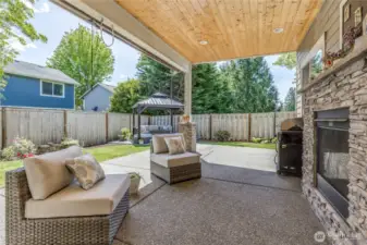 Covered patio with fireplace, sun/privacy shades and ceiling fan