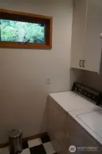 Laundry room off of the main hall has a full-size washer and dryer and extra storage.