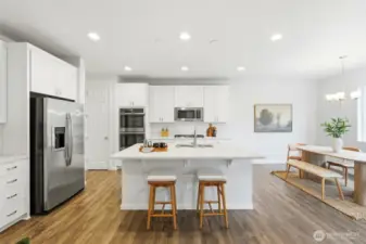 Kitchen has generous size island with quartz counters and breakfast bar