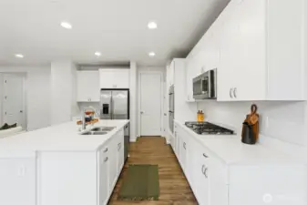 Kitchen features quartz countertops, stainless steel appliances and lots of cabinets