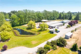This property features 30+ stalls including several with runs, two barns, a 120' x 60' covered indoor arena, and a 250' x 175' outdoor arena, all fully fenced and cross-fenced.