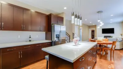 Gourmet kitchen with oversized island, quartz countertops, with hardwood floors throughout, opens to breakfast nook & family room with gas fireplace.