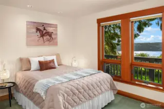 Main floor bedroom is across the hall from the full bath and has its own balcony with stairs down to pool area.