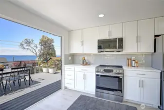 Modern gally kitchen with floor to ceiling glass door open.