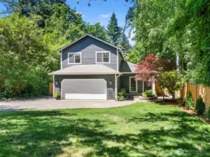 Front yard surrounded by established trees.