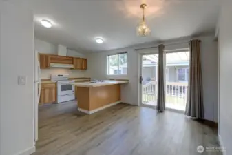 Open concept kitchen and dining area with new flooring, cabinet doors and newer range/oven and fridge.