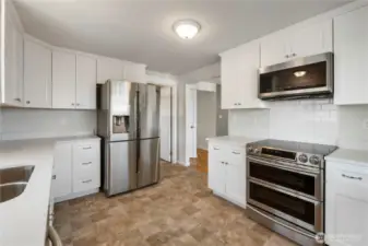 Fully updated kitchen with quartz counters, custom cabinets, stylish tile backsplash, and brand-new appliances that stay!