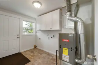 Spacious utility/mudroom with plenty of room to double as a pantry