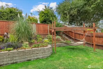Mature landscaping & a cool hammock trellis.