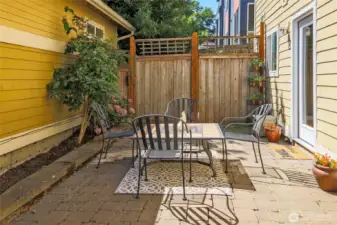 Private brick paver patio surrounded by gardens