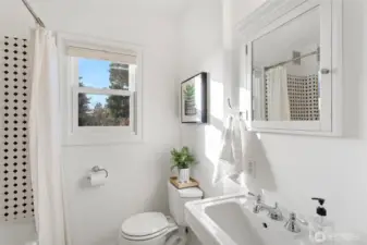 Main floor full bathroom with classic period tile and a pedestal sink