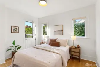 The main-floor hallway connects the living spaces with ease  —leading to a peaceful bedroom with its own balcony overlooking the tiered backyard,
