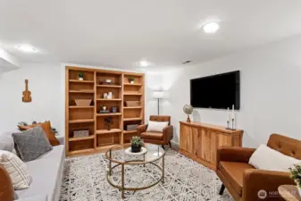 A wall of built-in wood bookshelves and French doors to the backyard create a welcoming retreat to relax and watch or play your favorite games.