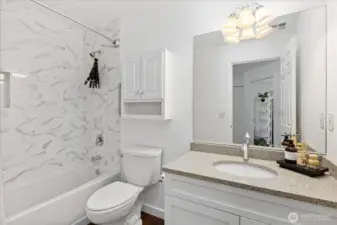 Guest bath with new tub, new tile surround  and updated cabinet fronts with newer hardware