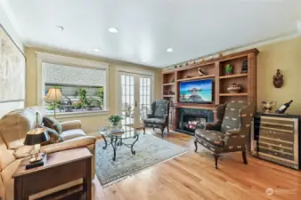 Family room with hardwood floors, crown molding, gas fireplace and built-in media center. French doors open to the courtyard.