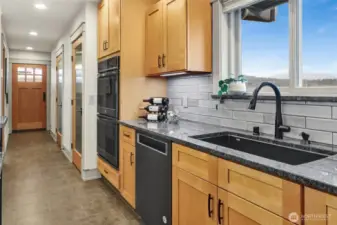 From the kitchen view of the hallway with the back door, laundry room, and walk-in pantry on the right