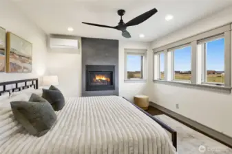 Upstairs find another spacious primary bedroom featuring a gas fireplace, views of the bay, and A/C with its own ductless mini-split