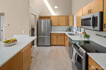 Chef-inspired kitchen with sleek quartz counters, maple cabinets, SS appliances and a lrg breakfast bar.