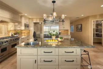 Huge island includes a prep sink and counter seating. Note the walk in pantry to the right in this photo.