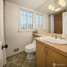 This full bath combines vintage charm and modern updates with a stained glass window that provides privacy without sacrificing light.