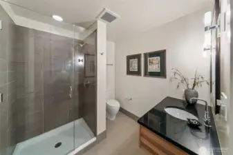 2nd bathroom offers tiled shower and sleek surfaces.