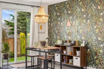 Dining area positioned beside sliding glass doors with backyard access, featuring a modern hanging light fixture and accent wall detail.