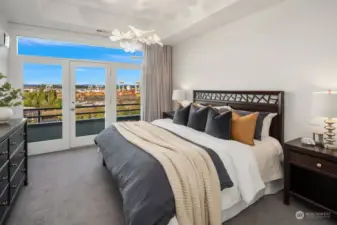 The primary bedroom features high ceilings, designer lighting and an expansive balcony with amazing views!