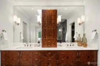 Custom primary bathroom floating vanity finished with elm burl veneer, with electrical outlets in top drawer, and soft close hinges and drawers. Beautiful marble countertop and polished nickel hardware throughout.