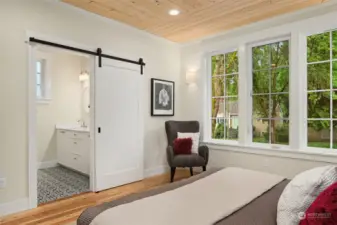 The custom tiled bath includes double sinks, gleaming quartz counters and heated tile floors