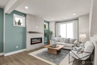 Living room has an electric fireplace for ambiance and surround sound speakers built in the ceiling.