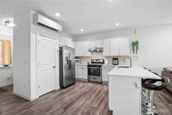 This kitchen is a cook's delight with stainless appliances, quartz countertops, and an extended eating bar.