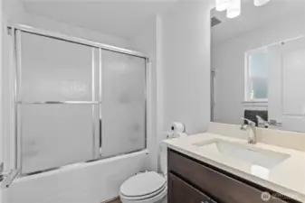 Private bath with a tub/shower combo off the primary bedroom.