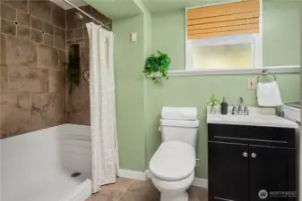 The lower bathroom features extensive tile work, an oversized shower and shares space with the laundry.