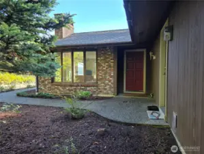 Front door, brick siding around bay window