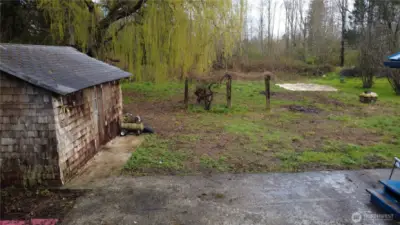 Backyard with established grape arbor.