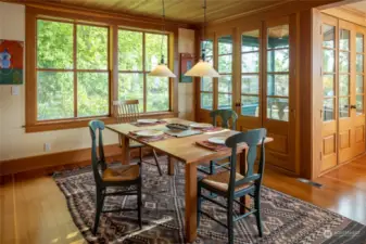 Dining area shows off the fir floors. Double set of French doors opens to one of the screened porches.