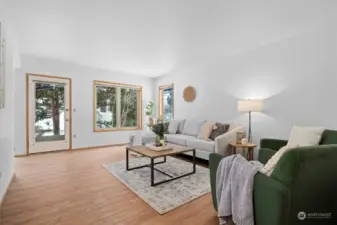 Spacious living room with lots of natural light. Door leads to back patio area.