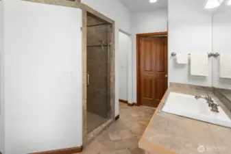 Luxurious custom tiled walk-in shower with glass door. Tiled counter and floors. Separate potty room.