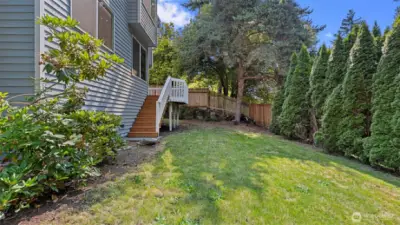 Newer deck and stairs down to a large backyard.