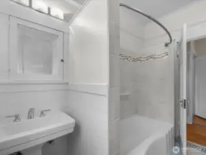 Main level guest bath. Nearby hallway has built-in drawers & cabinets.