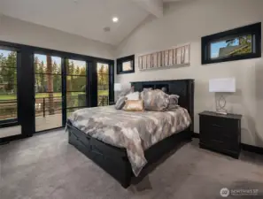 The primary suite has vaulted ceilings and large windows and a private deck