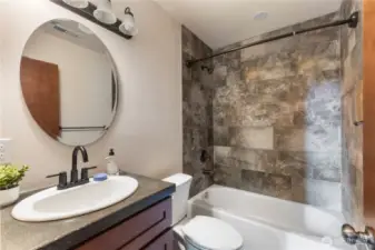 Downstairs hall bathroom has beautiful tiled bathtub