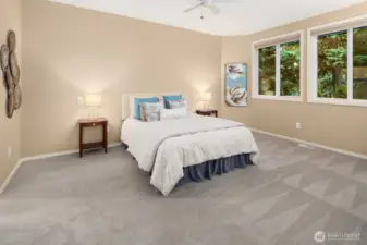 Large primary bedroom on main floor with windows that frame the serene views.