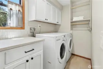 laundry room with sink, washer, dryer and storage