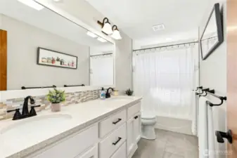 main bath with quartz counters and tiled flooring