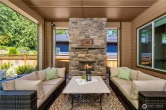 Huge, covered patio with a stone fireplace is an extension of the home and overlooks the beautiful permanent greenbelt.