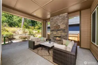 Huge, covered patio with a stone fireplace is an extension of the home and overlooks the beautiful permanent greenbelt.