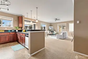 A view from the the kitchen overlooking the light and airy dining and living room with a door leading to you spacious patio.